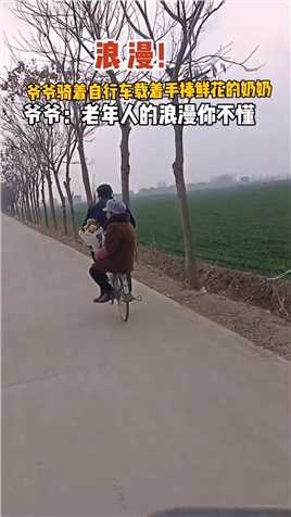 老年人的浪漫 爷爷骑着自行车载着手捧鲜花的奶奶
